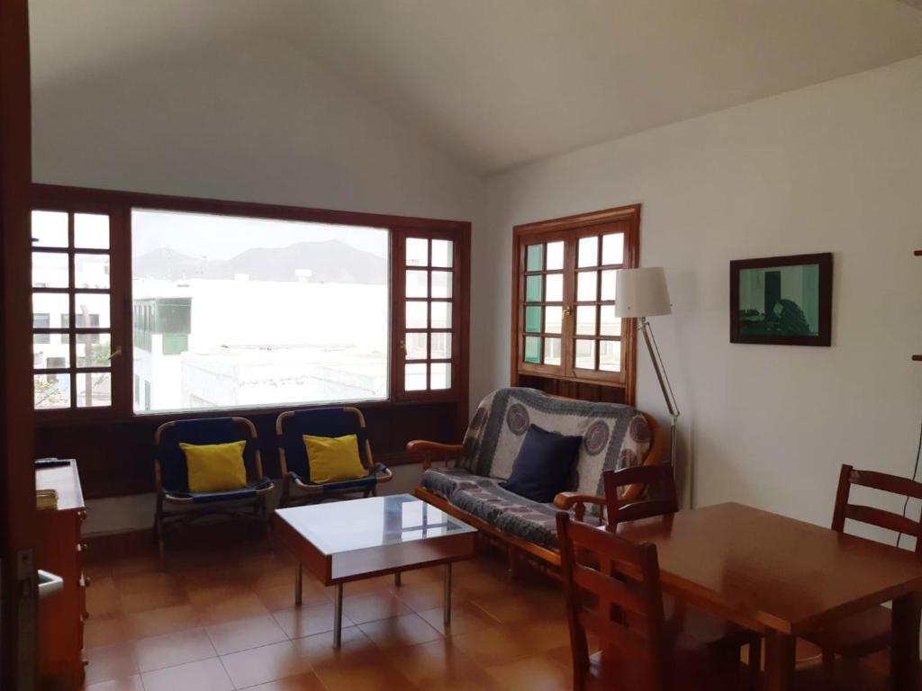 salon z kanapą, krzesłami i stołem w obiekcie La Laja 13 w mieście Playa Blanca