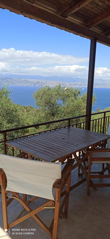 a picnic table on a balcony with a view of the water at Efi Loutses in Anapaftíria