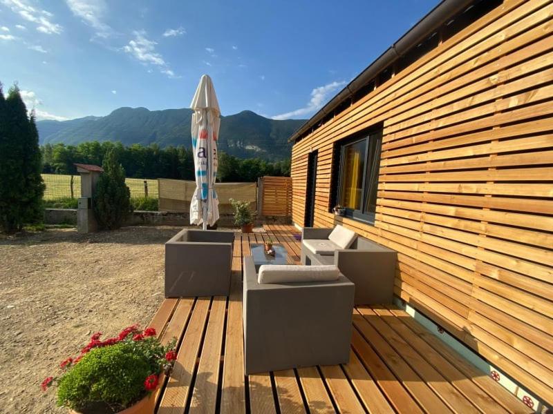 a patio with an umbrella and two couches and an umbrella at Apartments Radulje Bovec in Bovec