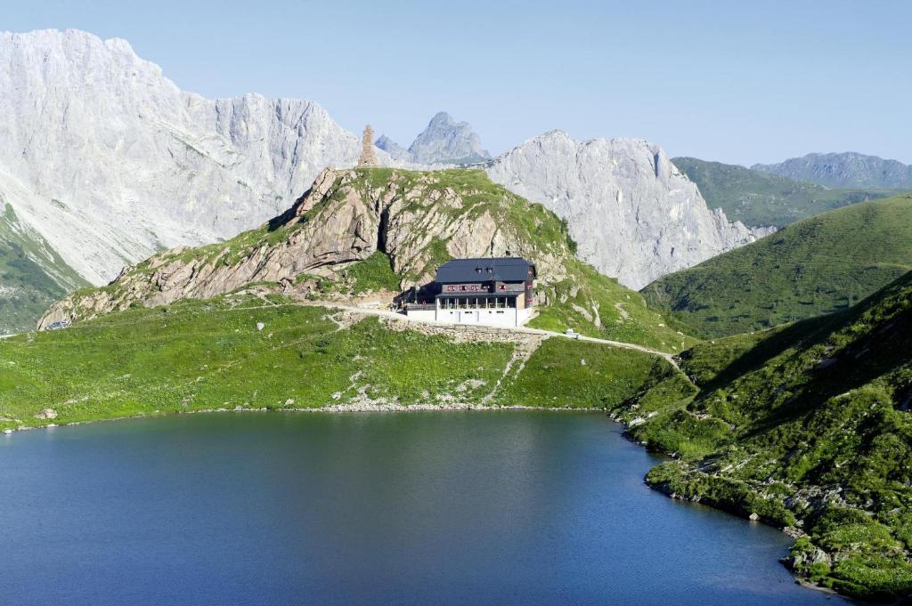 a house on the side of a mountain with a lake at Ferienwohnung Hain in Birnbaum