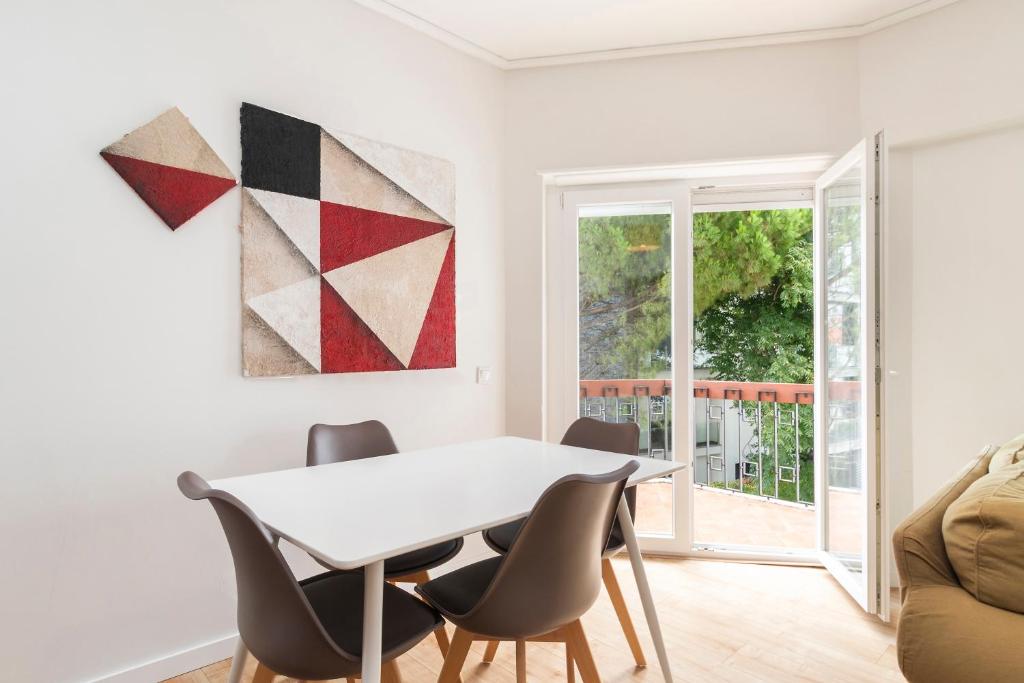 a dining room with a white table and chairs at PAREDE APARTMENT 2 in Cascais