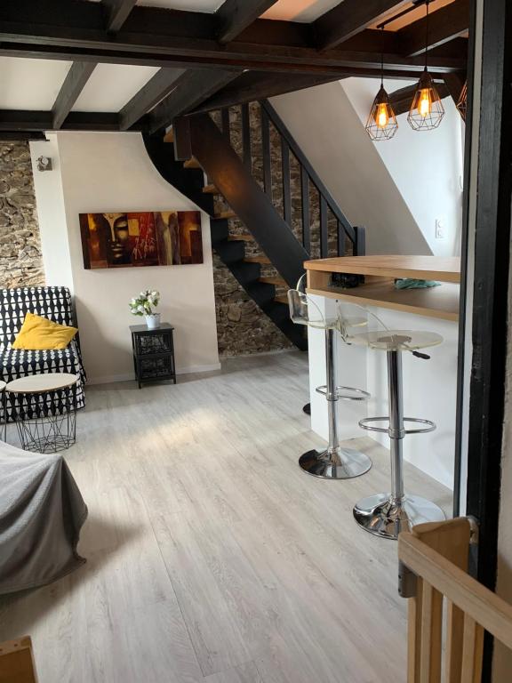 a living room with a staircase and a table at Le bas-sablons in Saint Malo