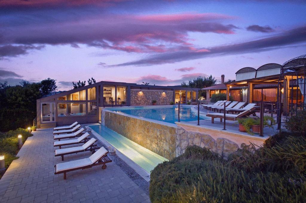 una casa con piscina y un edificio en Villa Hotel Valle Del Marta Resort en Tarquinia