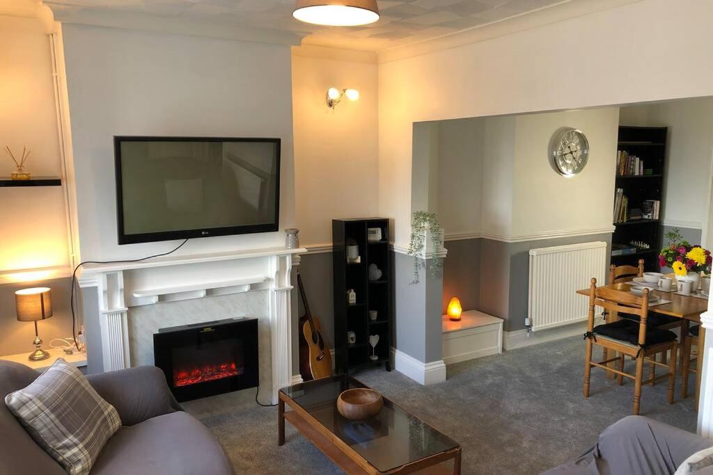 a living room with a fireplace with a tv above it at Clives Place - End of terrace two bedroom cottage in Cwm-brân