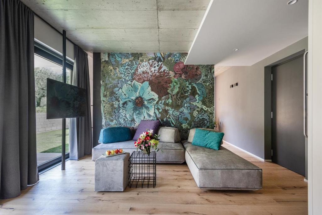 加爾達湖濱的住宿－OLEEVA Garda Living，带沙发和花卉墙的客厅