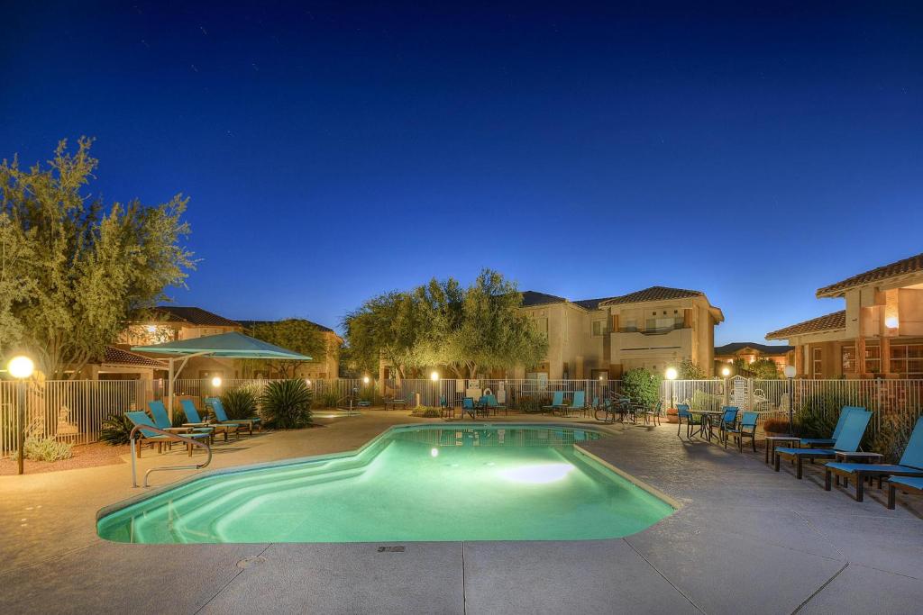 uma piscina à noite com cadeiras e mesas em Vistoso Resort Casita 244 em Oro Valley