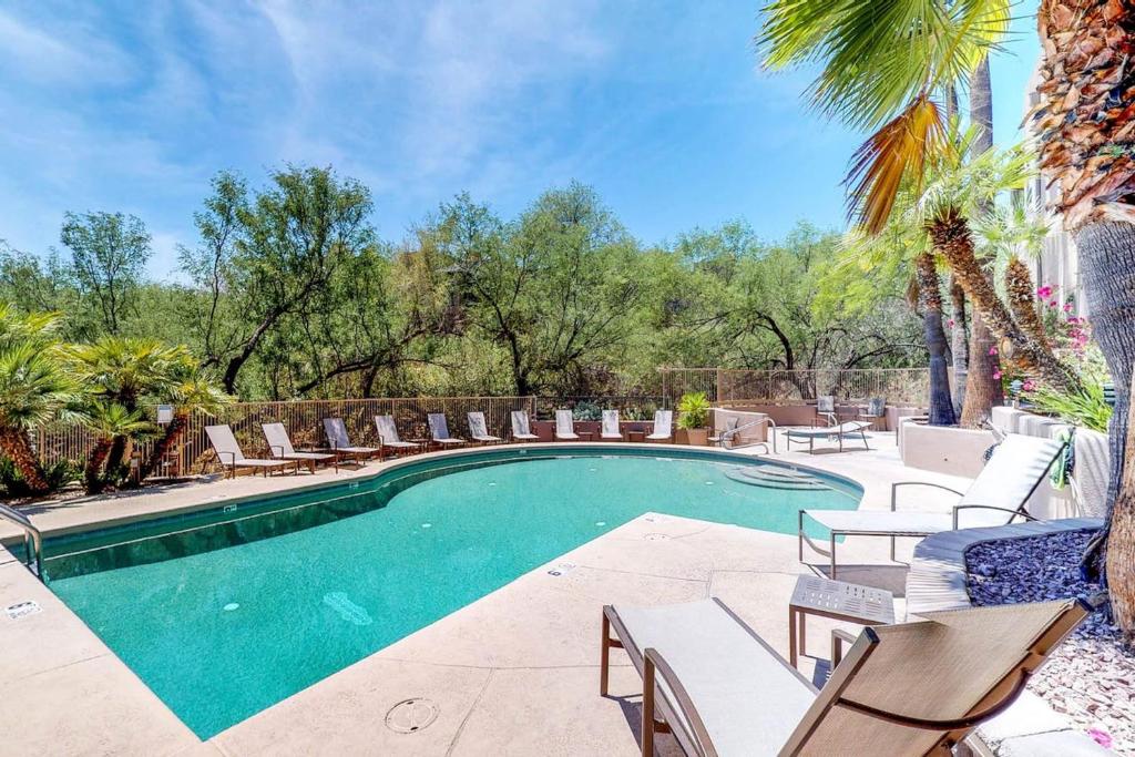 uma piscina com espreguiçadeiras e cadeiras em Canyon View em Tucson