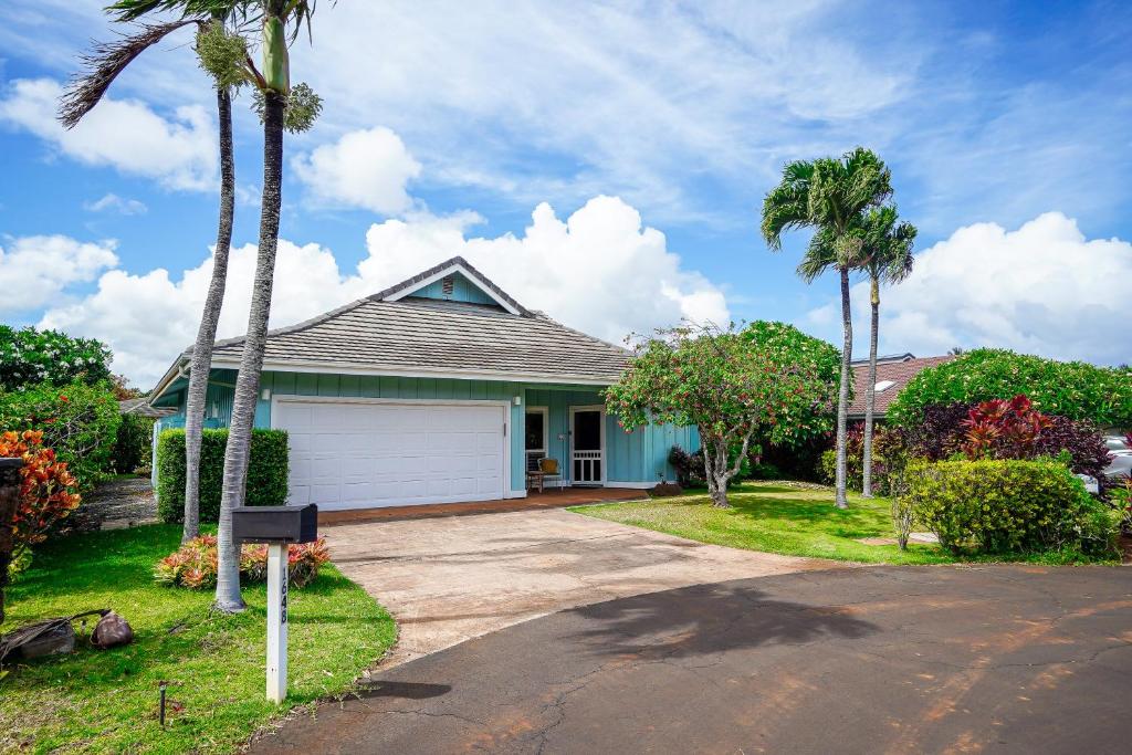 a house with palm trees and a driveway at Hale Polu in Koloa