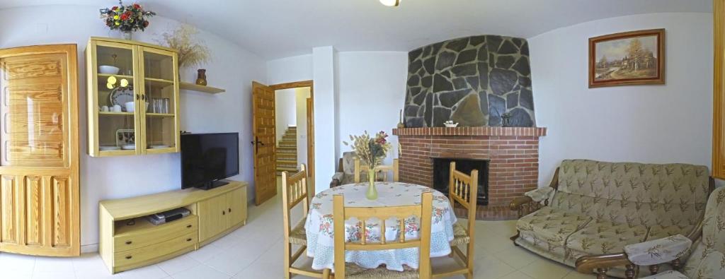 2 fotos de una sala de estar con chimenea en CASASBLANCAS. Casa nr 5 en Alpujarra de la Sierra