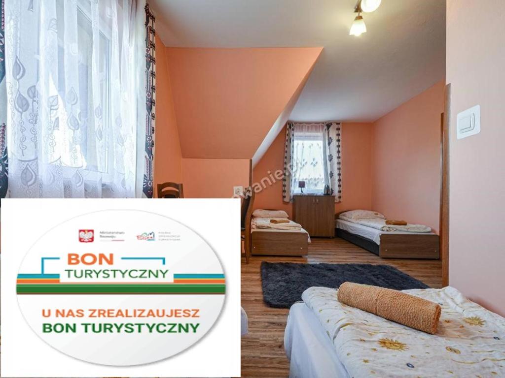a room with two beds and a sign that says born tum sqor at Dom Wczasowy " U Józefa " in Zakopane