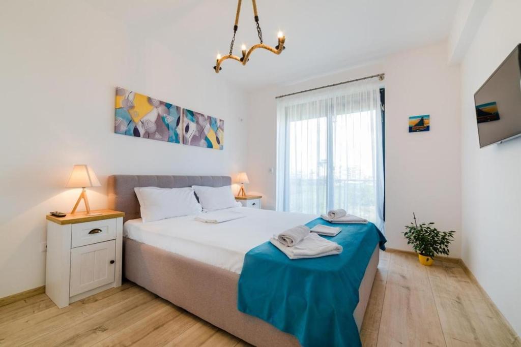 a bedroom with a bed with a blue blanket on it at Sorrento Apartment in Năvodari