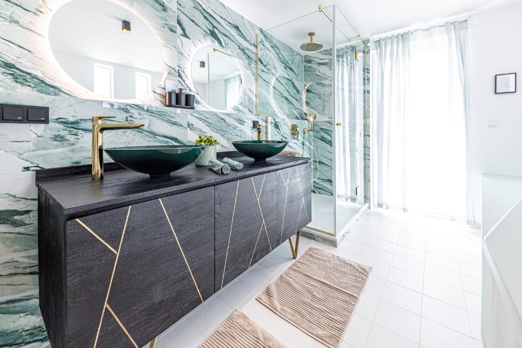 Baño con 2 lavabos y espejo en d&v living en Viena