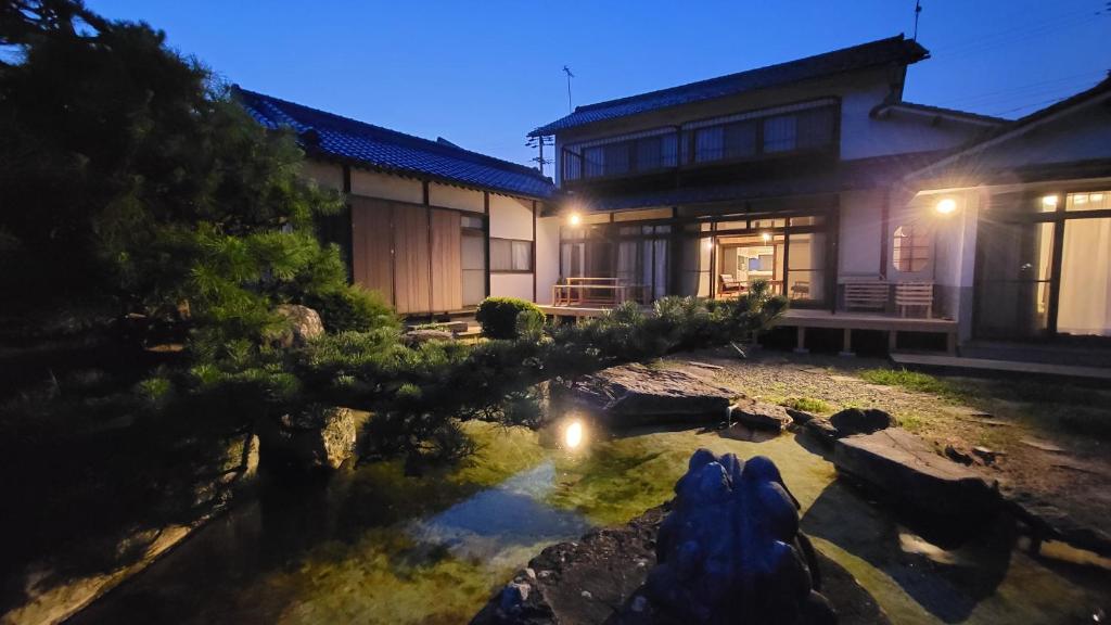 Kurita的住宿－1日1組限定 プライベート空間 古民家貸切コテージとけい，前面有池塘的房子