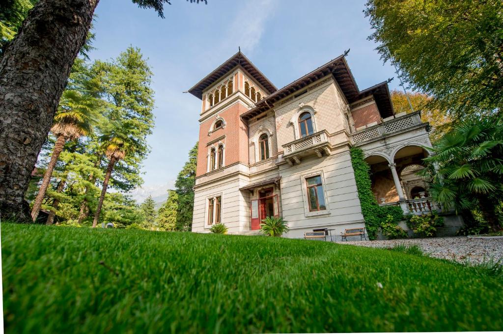 an old house on a hill with green grass at Villa Confalonieri in Mandello del Lario