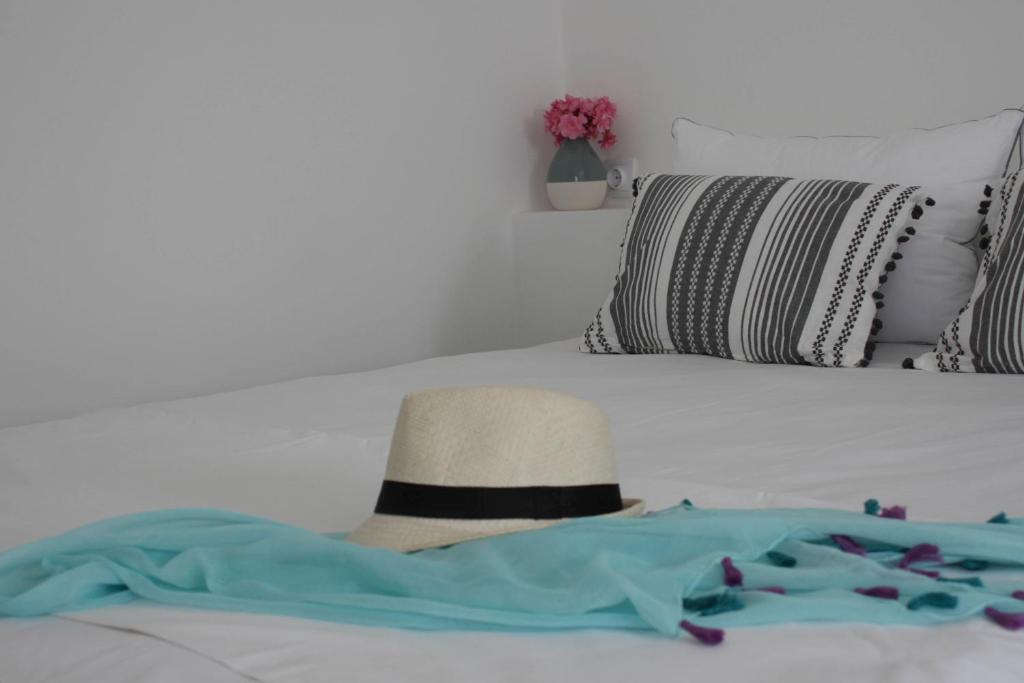 a hat sitting on top of a bed with flowers at Alkyon Hotel in Parikia