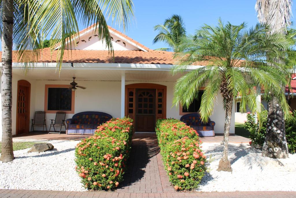 una casa con dos palmeras y un porche en Villa Serenidad, en Paquera