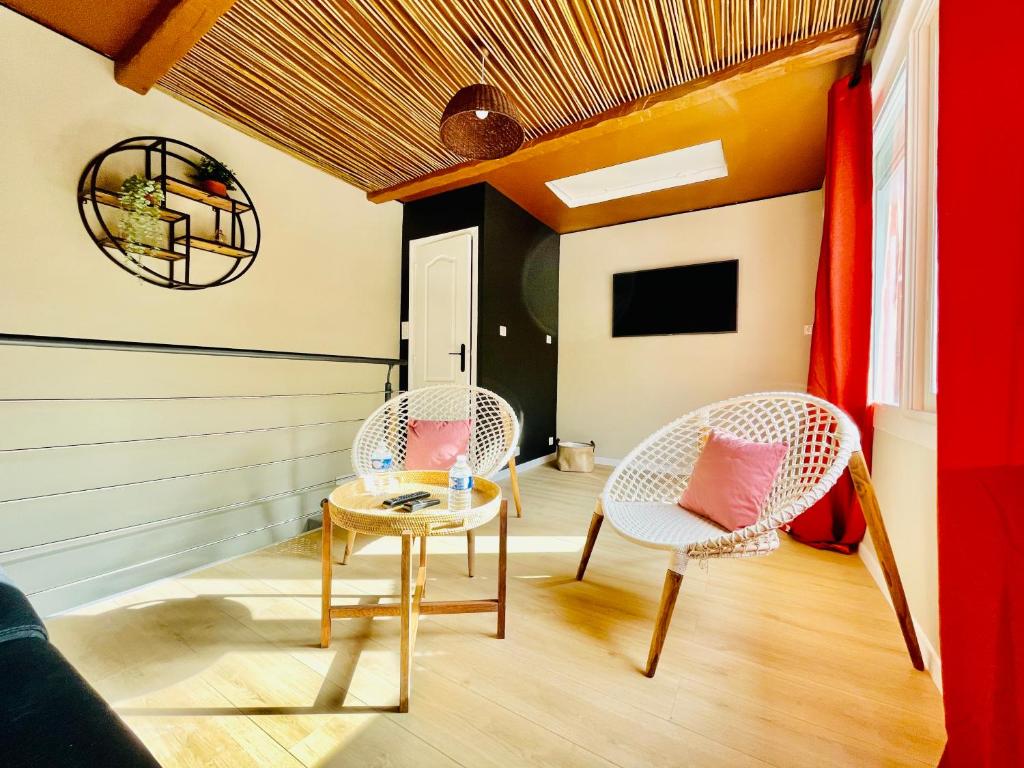un salon avec deux chaises et une table dans l'établissement Suite souplex Païka, à Montpellier