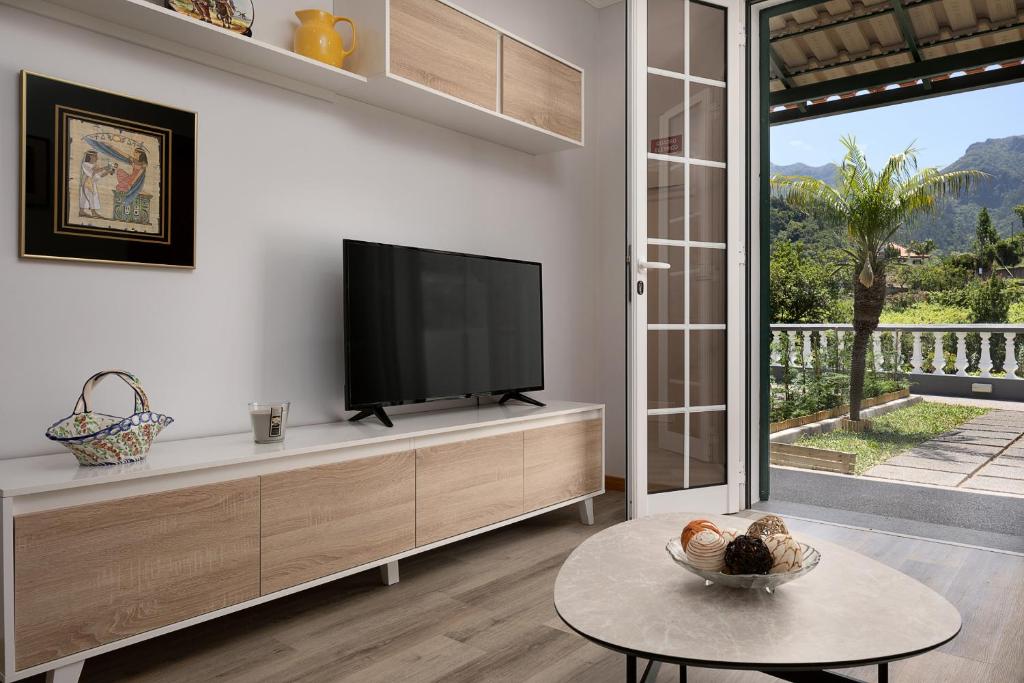 a living room with a flat screen tv on a wall at Vila do Largo by Madeira Sun Travel in São Vicente