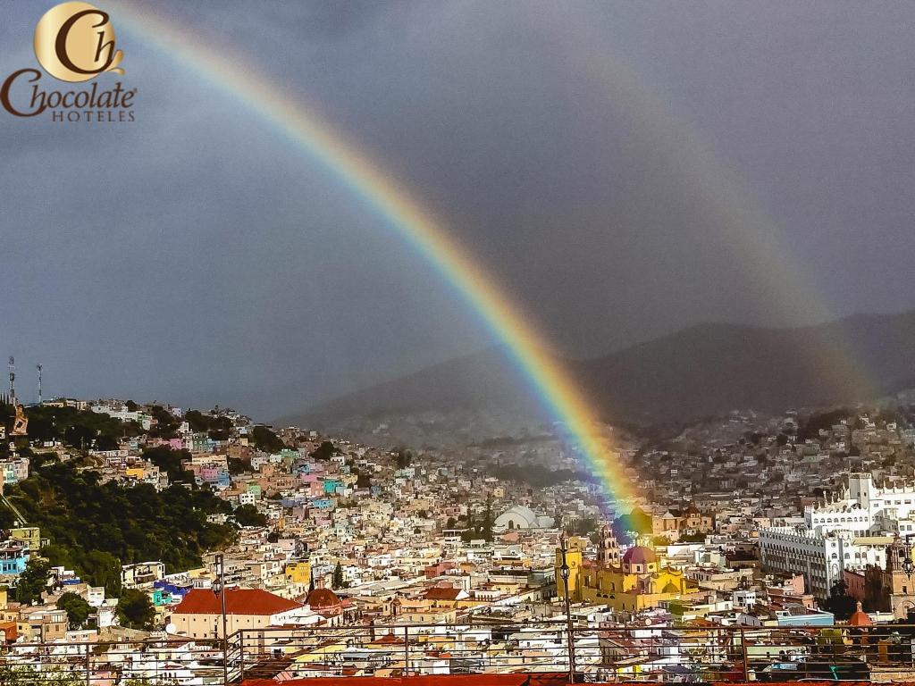 a rainbow in the sky over a city at Hotel Chocolate Suites in Guanajuato