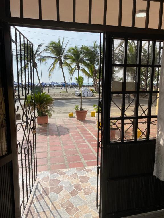 eine offene Tür, die auf eine Terrasse mit Palmen führt in der Unterkunft Habitación I frente a la playa ( Bocagrande ) in Cartagena de Indias