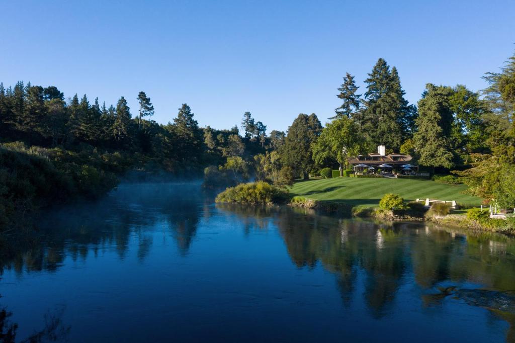 a view of a river with a house in the background at Huka Lodge in Taupo