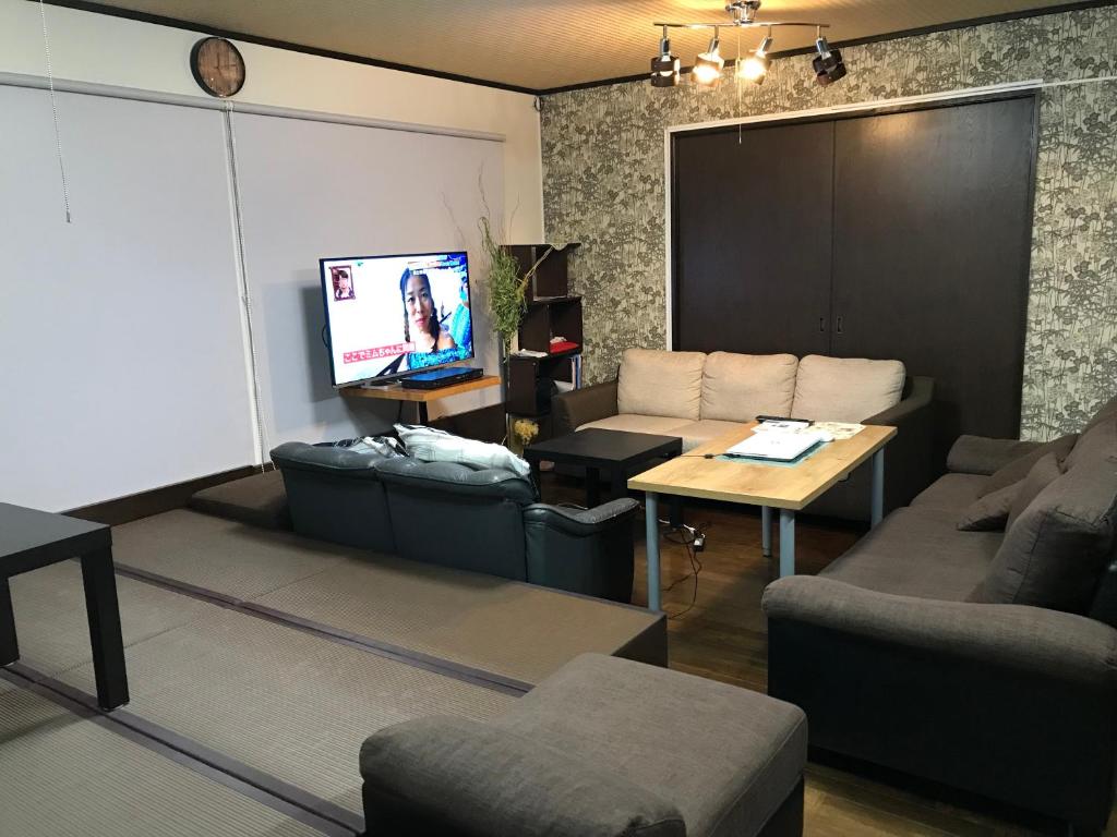 a living room with a couch and a tv at オソレイユ in Okayama