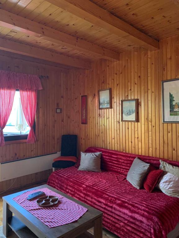 una camera con letto rosso e tavolo di Chalet Hill Zabljak a Žabljak