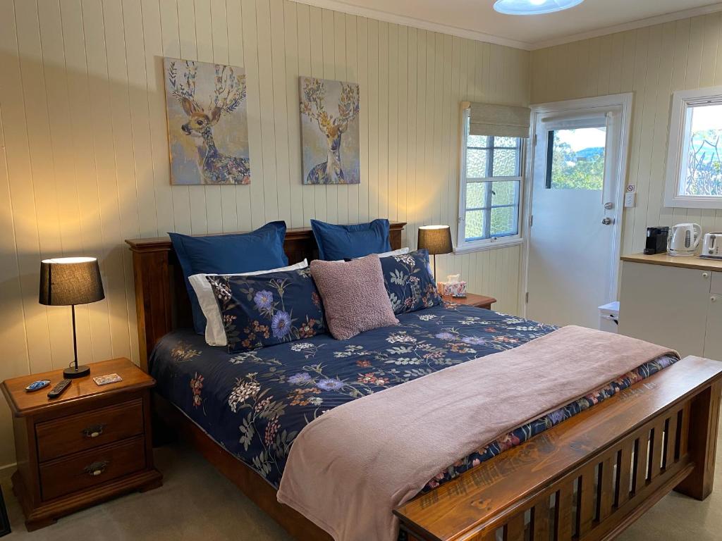 a bedroom with a large bed with blue sheets at Hideaway on Hume #3 in Boonah