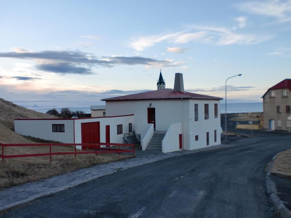 un pequeño edificio blanco al lado de una carretera en Guesthouse Tilraun, en Blönduós