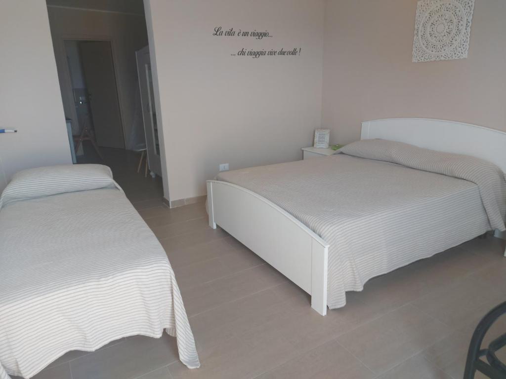 2 łóżka w pokoju z białymi ścianami w obiekcie Li Tisi w mieście Supersano