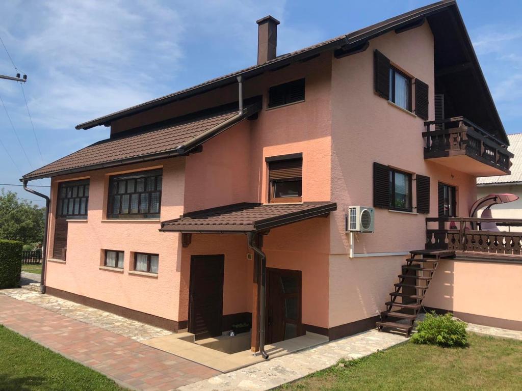 a large house with a staircase on the side of it at Plitvice Family Apartment in Korenica