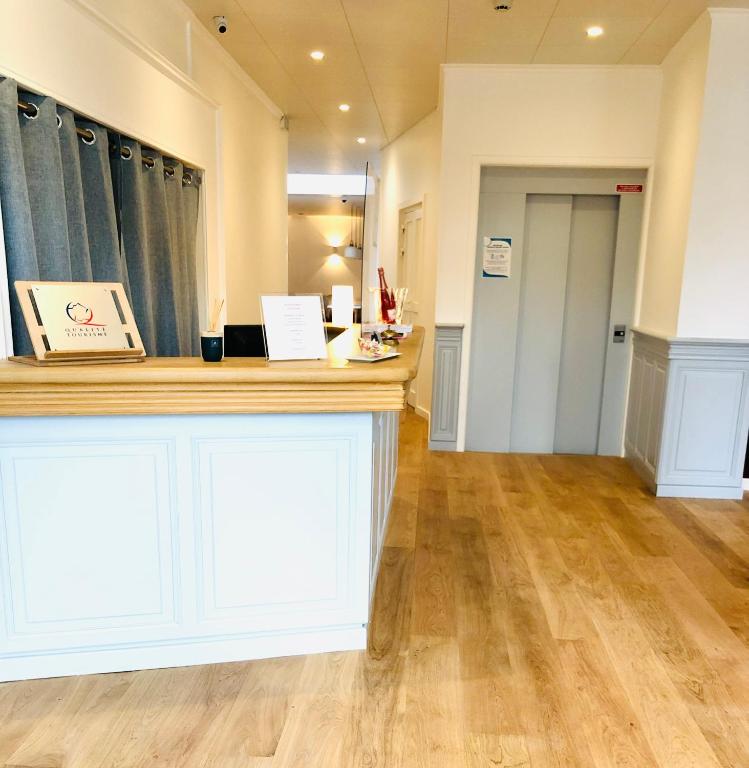 a large room with a counter and wooden floors at Hôtel Porte Mars Reims Gare Centre Arena in Reims