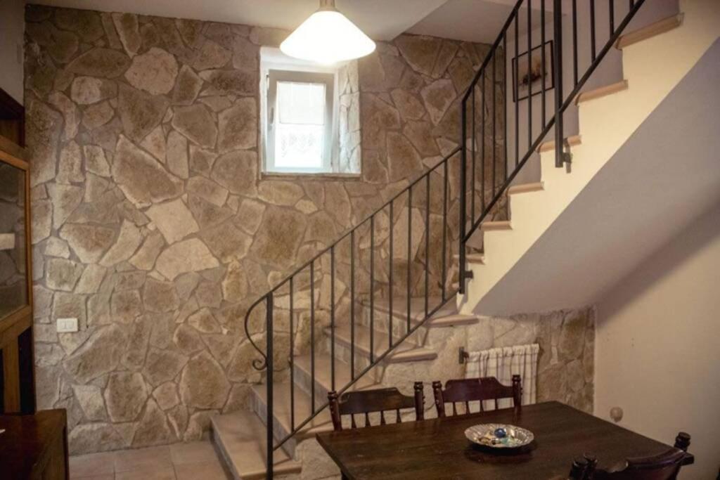 um quarto com uma escada e uma parede de pedra em VICOLOSEI em Colli a Volturno