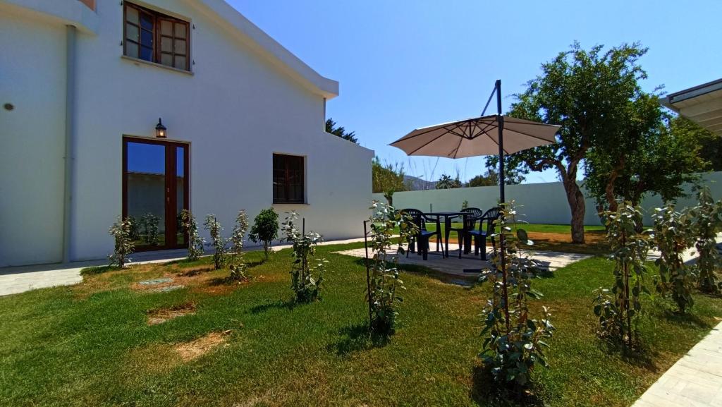 patio ze stołem i parasolem na dziedzińcu w obiekcie DOMU NOSTA di Giulio & Ignazia Room1 w mieście Santa Luria