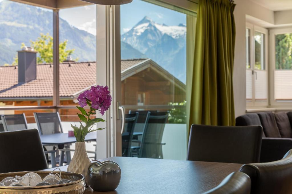 a dining room table with a view of a mountain at Fourteen Zell am See S&P by All in One Apartments in Zell am See