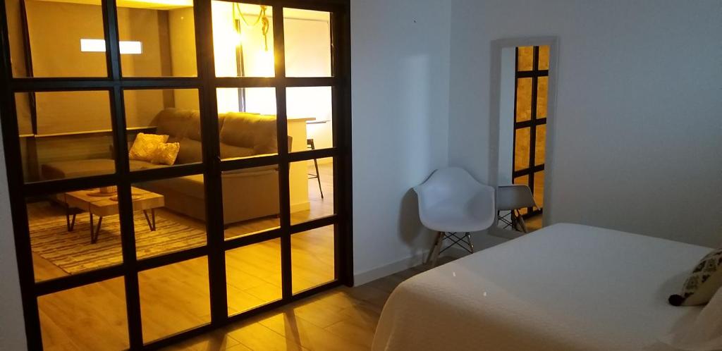 um quarto com uma cama e uma sala de estar com um sofá em Vivienda Turística Jaén Interior PARKING GRATUITO em Andújar