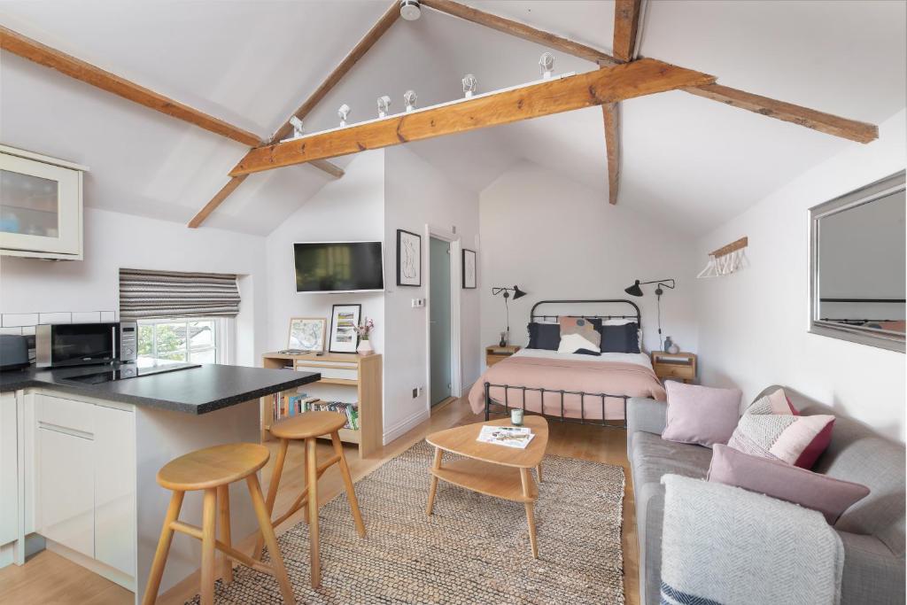 a kitchen and living room with a bed and a couch at The Hayloft by Black Door Stays in Bath
