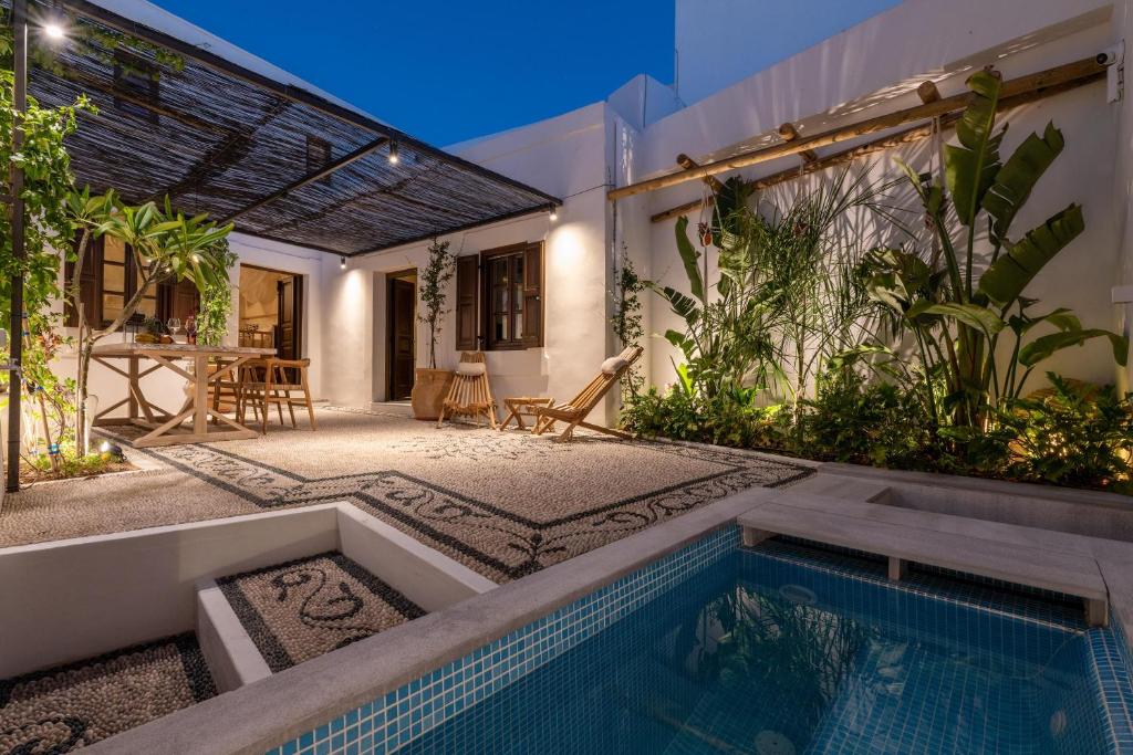 a backyard with a swimming pool and a house at Lindian Plumeria in Líndos