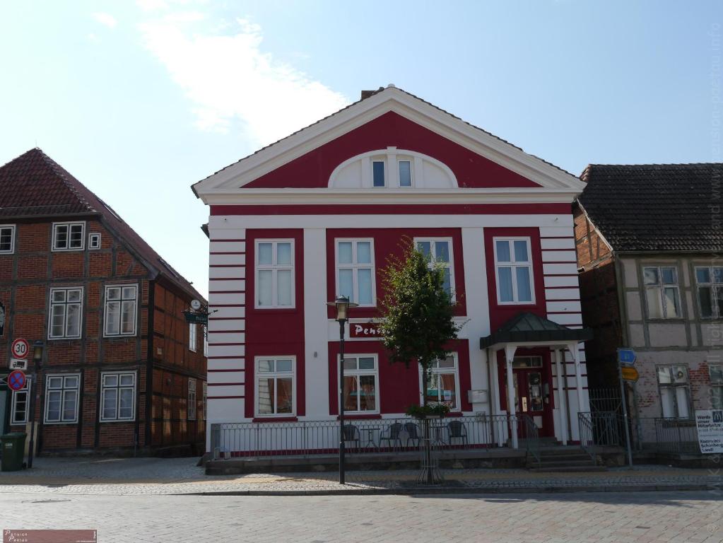 ein rotweißes Gebäude auf einer Straße in der Unterkunft Pension Paetau in Schönberg