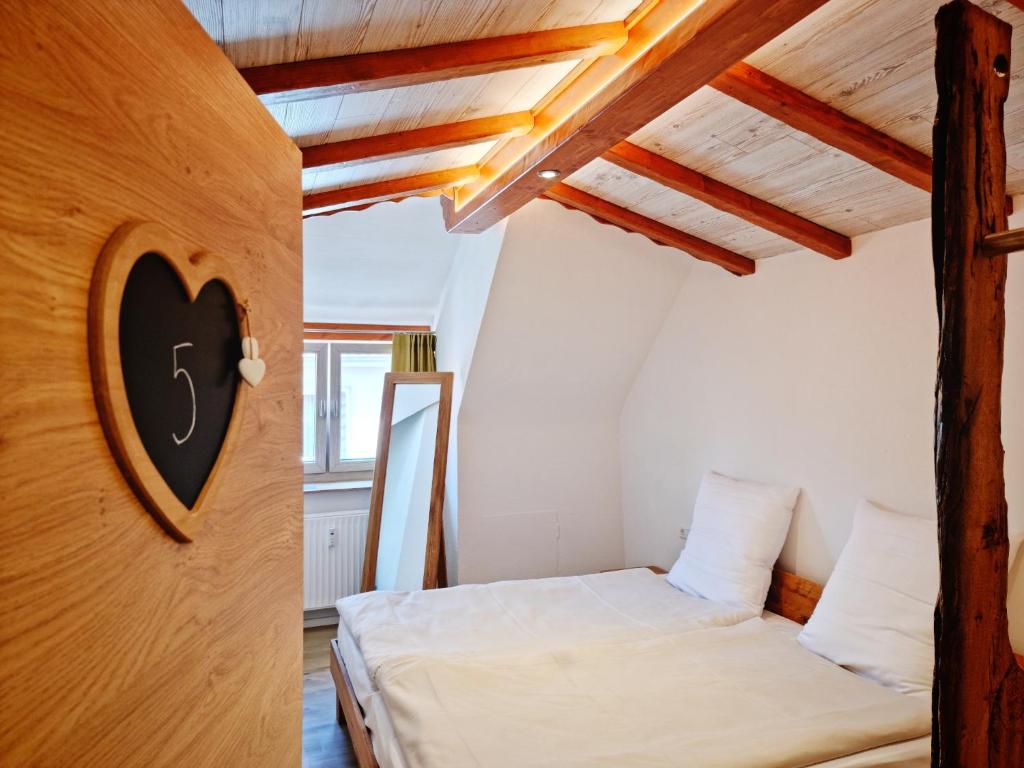 a bedroom with two beds in a room with wooden ceilings at Wirtshaus Zum Lowen in Steinenbronn