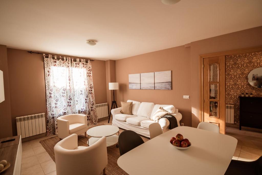sala de estar con sofá, mesas y sillas en Apartamento Tremedal en El Barco de Ávila