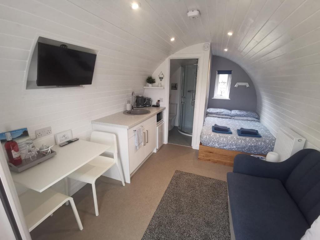 Habitación pequeña con cama y lavabo. en Loch Ness Pods, Pod 2 en Fort Augustus