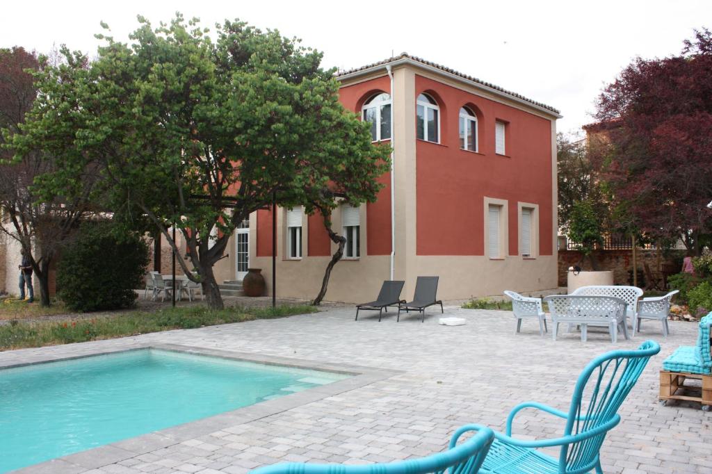 una casa con sedie e una piscina di fronte di Casa Rural La Rosaleda de Pajares a Pajares