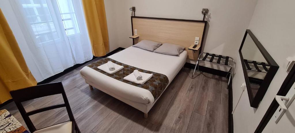 1 dormitorio con 1 cama con 2 almohadas en Hôtel Renova, en Nantes