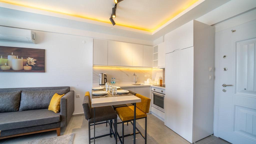 cocina y sala de estar con sofá y mesa en Midpoint Suites, en Fethiye