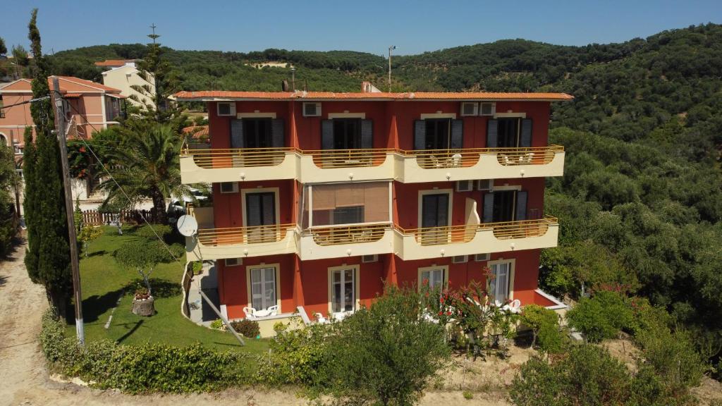 widok z góry na duży czerwony budynek w obiekcie Lofos ClaudiAgapi Guesthouse Seaview w mieście Agios Stefanos