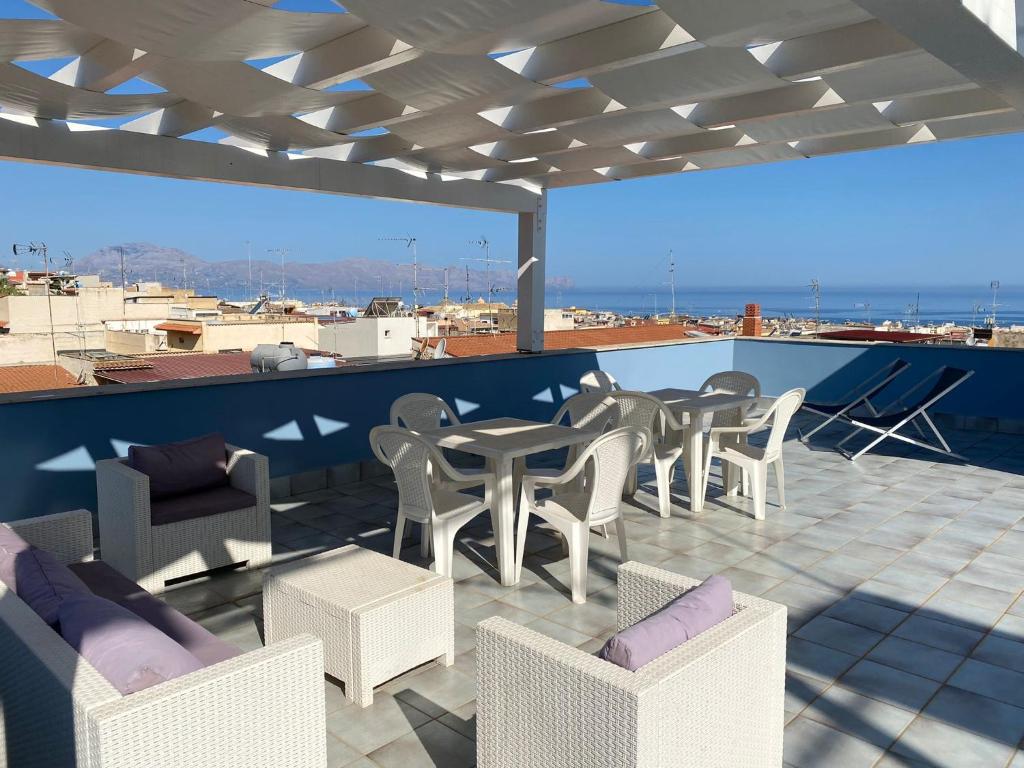 een patio met stoelen en tafels op een dak bij Stella Maris Case Vacanze in Balestrate