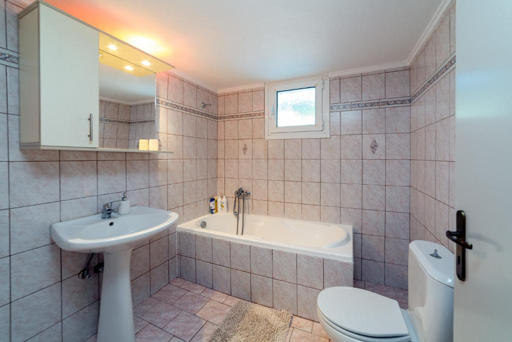 łazienka z umywalką, wanną i toaletą w obiekcie Artemis apartment w mieście Gázion
