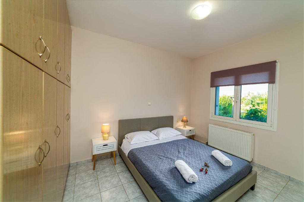 sypialnia z łóżkiem z dwiema poduszkami i oknem w obiekcie Artemis apartment w mieście Gázion