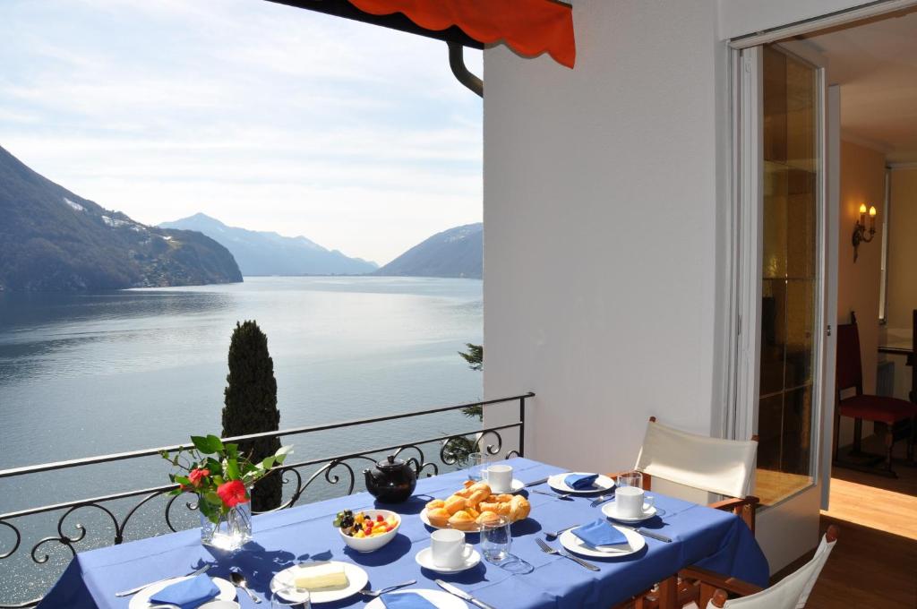 un tavolo blu con vista sull'acqua di Villa Sassalto a Lugano
